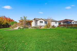 Fenced backyard featuring a pergola