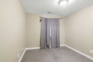 Empty room with baseboards and a textured ceiling