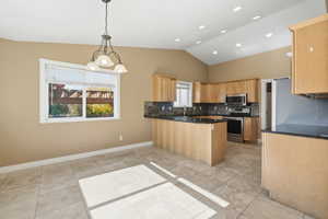 Kitchen featuring decorative backsplash, a peninsula, pendant lighting, stainless steel appliances, and light tile patterned floors