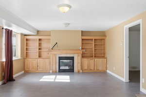 Unfurnished living room with baseboards and a fireplace