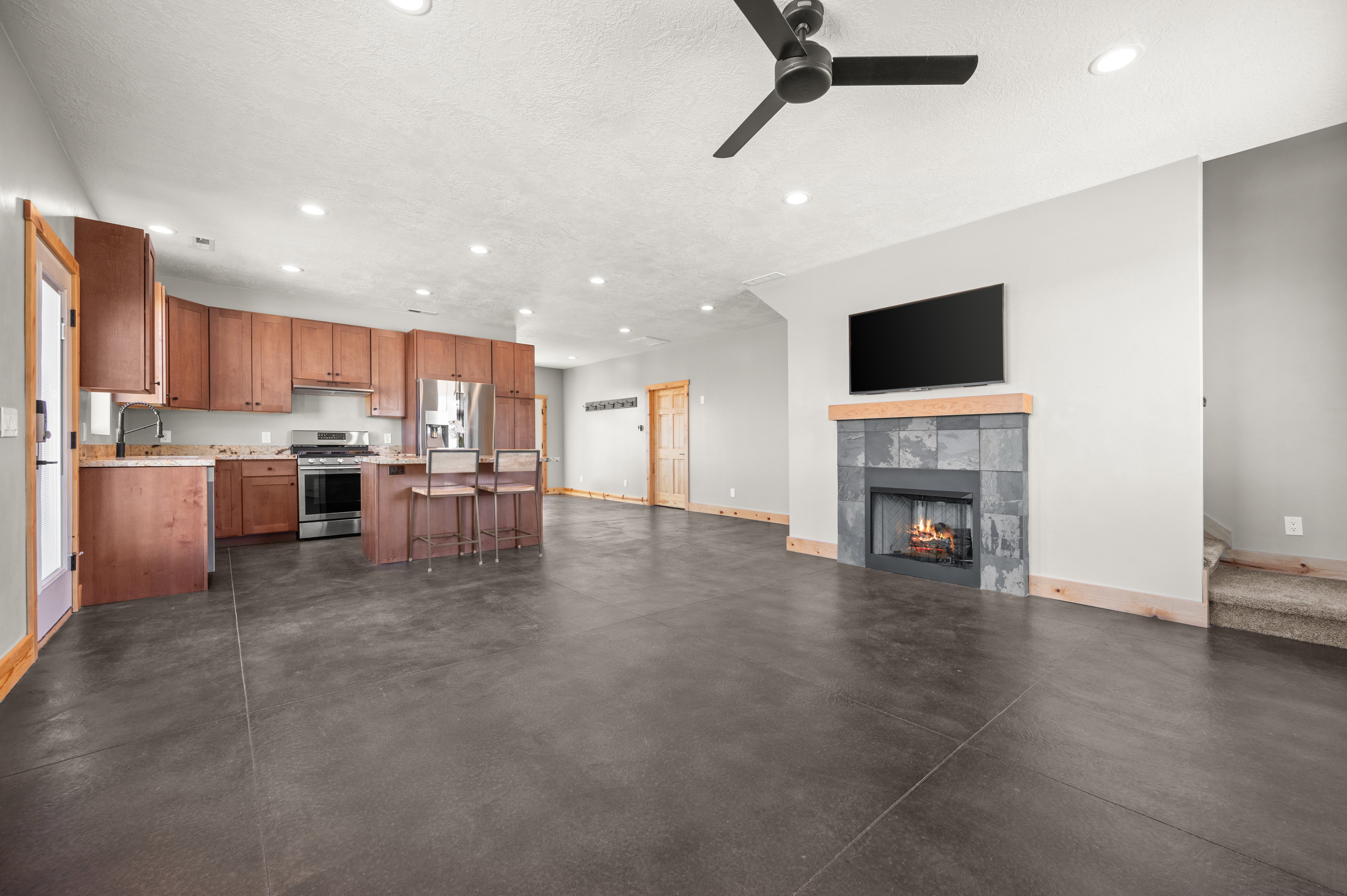 Kitchen with light countertops, open floor plan, appliances with stainless steel finishes, recessed lighting, and brown cabinets