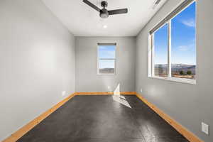Empty room featuring baseboards and ceiling fan