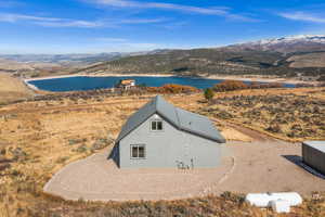 Aerial view of property and surrounding area with a water and mountain view