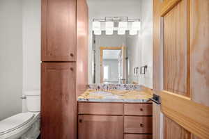 Half bathroom with vanity and toilet