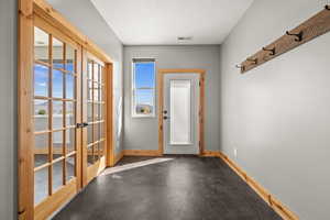 Doorway to outside featuring french doors and baseboards