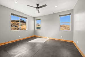 Unfurnished room with concrete floors, recessed lighting, a ceiling fan, a textured ceiling, and a mountain view