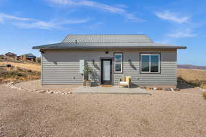 Back of property with a patio area and a metal roof
