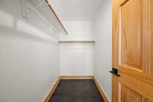 Walk in closet featuring dark carpet