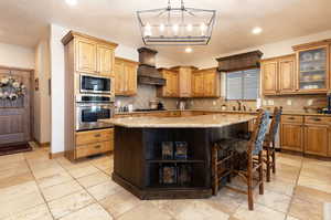 Kitchen with a textured ceiling, appliances with stainless steel finishes, light stone countertops, glass insert cabinets, and open shelves