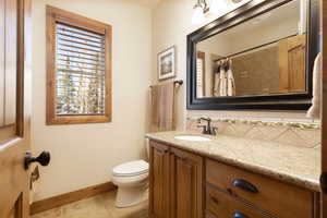 Bathroom featuring vanity, a shower with shower curtain, light tile patterned floors, and backsplash
