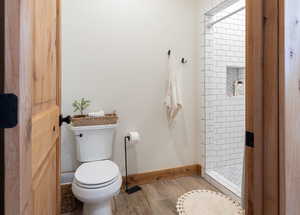Bathroom with a stall shower and wood finished floors