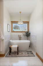 Bathroom with a soaking tub and tile walls