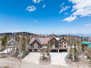 View of front facade with stone siding, concrete driveway, and a mountain view