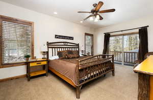 Bedroom with light colored carpet, a textured ceiling, a ceiling fan, recessed lighting, and access to exterior
