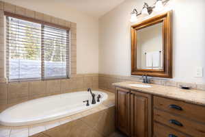 Bathroom featuring a garden tub and vanity
