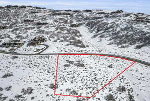 Snowy aerial view featuring property boundaries highlighted and a mountain view