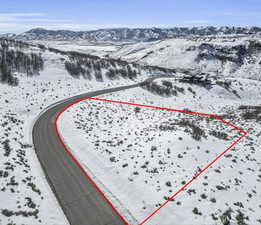 Snowy aerial view featuring property boundaries highlighted and a mountain view