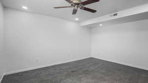 Unfurnished room featuring dark colored carpet, recessed lighting, and a ceiling fan