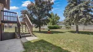 View of yard with stairway, a patio, and a wooden deck