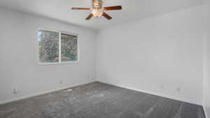 Spare room featuring carpet and ceiling fan
