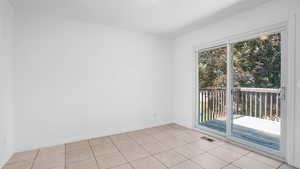 Spare room featuring light tile patterned floors and baseboards
