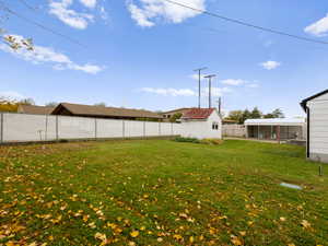 Fenced backyard featuring a storage shed