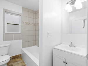 Bathroom with white vanity, tile shower, and tile flooring