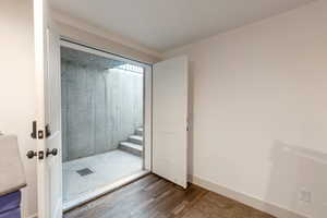 Bathroom featuring a shower stall and dark wood-type flooring