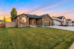 View of front of property with stone siding, concrete driveway, a garage, a gate, and covered porch