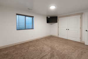 Unfurnished bedroom featuring carpet and a closet