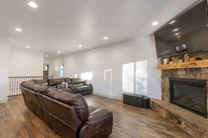 Living room featuring wood finished floors, a fireplace, and recessed lighting