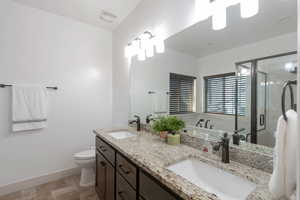 Full bath featuring double vanity, a shower stall, and a bath