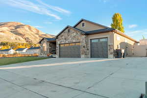 Craftsman-style house with a gate, concrete driveway, a garage, and stone siding