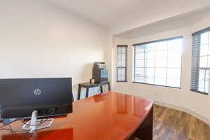 Home office with dark wood finished floors and baseboards
