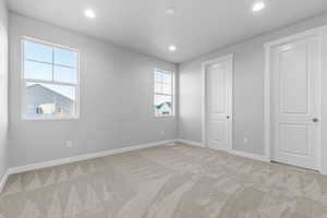 Unfurnished bedroom featuring light carpet and recessed lighting