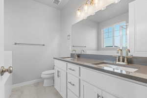 Full bathroom with double vanity, light marble finish flooring, and a stall shower