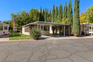 Manufactured / mobile home featuring a carport and a front lawn