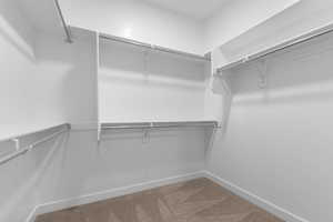 Walk in closet featuring light colored carpet