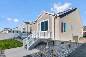 View of side of property featuring a wooden deck and stucco siding