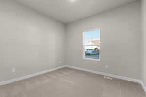Carpeted spare room with baseboards