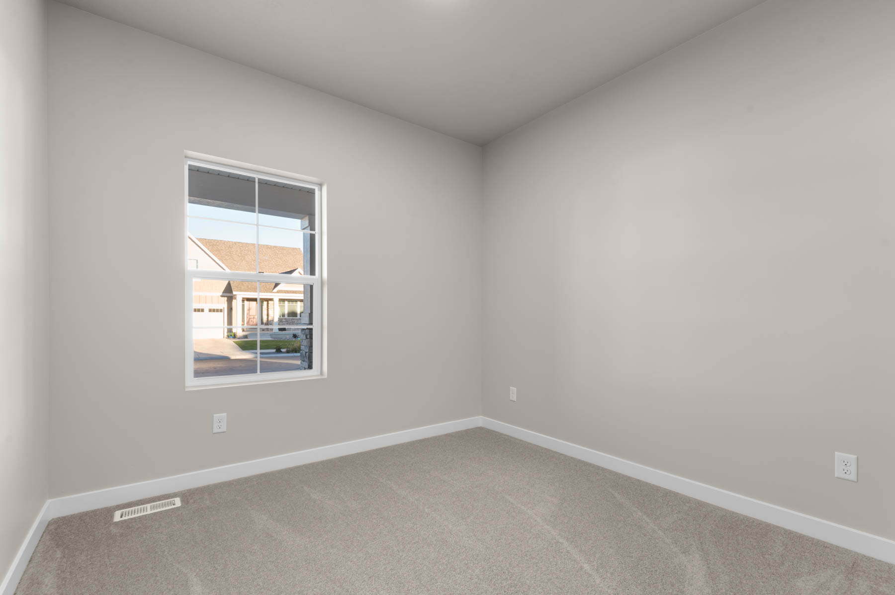 Carpeted spare room featuring baseboards