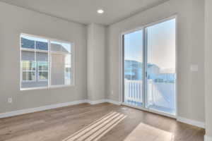 Unfurnished room with plenty of natural light, light wood-style flooring, and recessed lighting