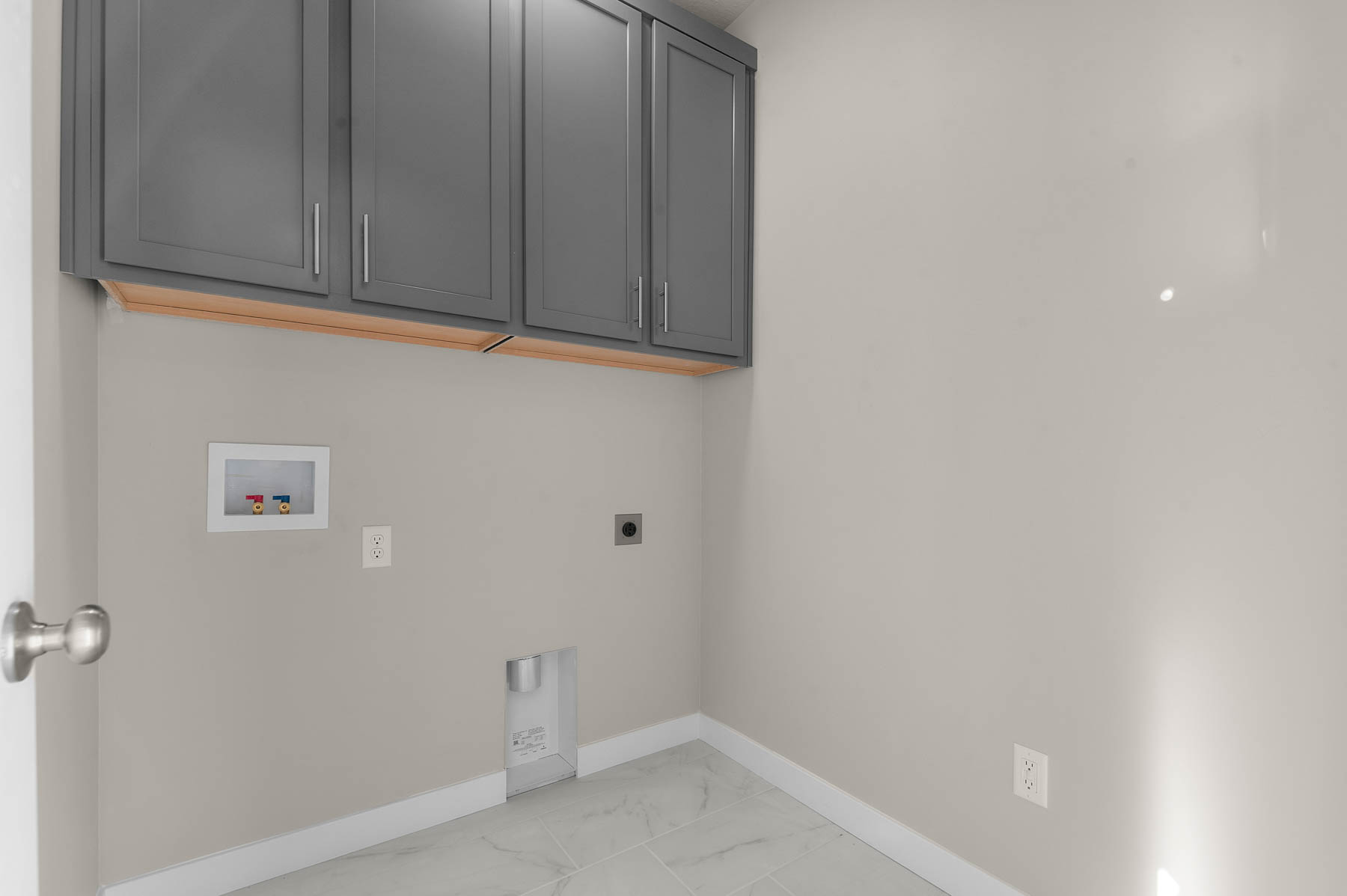 Laundry room featuring light marble finish floors, electric dryer hookup, hookup for a washing machine, and cabinet space
