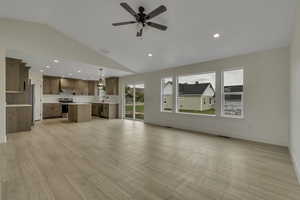 Unfurnished living room featuring lofted ceiling, recessed lighting, light wood finished floors, and ceiling fan