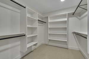 Spacious closet with light carpet
