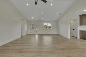 Spare room featuring vaulted ceiling, recessed lighting, light wood finished floors, and ceiling fan