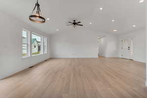 Unfurnished living room with light wood-type flooring, lofted ceiling, recessed lighting, and a ceiling fan