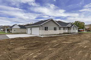 Craftsman-style house with board and batten siding, stone siding, concrete driveway, a shingled roof, and an attached garage