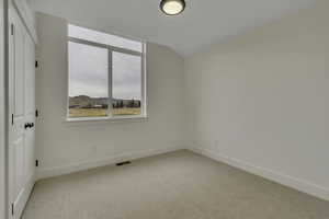 Carpeted spare room with baseboards