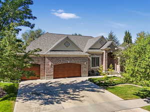 French country home with driveway, brick, roof with shingles, and a front lawn